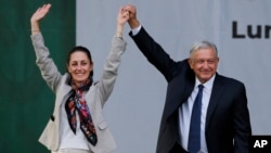 En esta imagen de archivo, el presidente de México, Andrés Manuel López Obrador (derecha), y la entonces alcaldesa de la Ciudad de México, Claudia Sheinbaum, saludan a sus partidarios en un mitin en la principal plaza de la capital, el Zócalo, el 1 de julio de 2019.