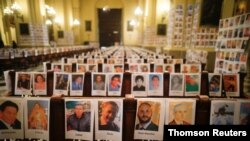Fotografías de las víctimas peruanas de la enfermedad del COVID-19 se ven en los bancos y las paredes de la Catedral de Lima durante una misa oficiada por el arzobispo Carlos Castillo, en Lima, Perú, el 14 de junio de 2020.