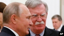 Russian President Vladimir Putin, left, and U.S. President Donald Trump's National Security Adviser John Bolton are seen during their meeting in the Kremlin, in Moscow, Russia, Oct. 23, 2018.