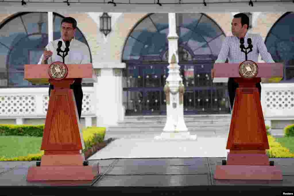 Honduras' President Juan Orlando Hernandez speaks next to his counterpart, Guatemala's President Jimmy Morales, during a news conference in Guatemala City, Guatemala, Oct. 20, 2018. to talk about the situation of the large caravan of Central American migrants who are trying to reach the United State.