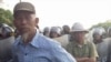 Villagers stand next to riot police deployed to Vietnam's northern Hung Yen province during a protest on April 24, 2012. Local residents tried block police from taking control of a disputed plot of land outside Hanoi in the second high-profile clash over 