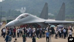 Posetioci gledaju kineski borbeni avion J-16D tokom 13. kineske aero-svemirske izložbe, poznate kao Aerošou Kina 2021, 29. septembra 2021, in Žuhaju u južnoj kineskoj pokrajini Guangdong.
