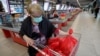 Montenegro, Podgorica, A woman wears a mask as she packs her groceries