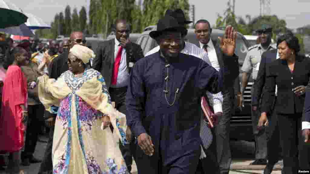 Le président Goodluck Jonathan du Nigeria (C) et sa femme saluent de la main des électeurs en file, attentant de voter à Otuoke, dans l'État de Bayelsa, le 28 mars 2015.