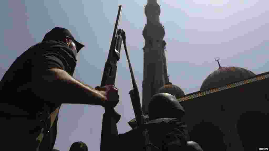 Armed Egyptian policeman moves into position in front of al-Fath mosque on Ramses Square in Cairo, August 17, 2013.