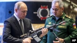 El presidente ruso, Vladimir Putin (izq), y el ministro de Defensa ruso, Sergei Shoigu, visitan una exhibición militar después de asistir a una reunión de la Junta del Ministerio de Defensa de Rusia en el Centro de Control de Defensa Nacional en Moscú, el 21 de diciembre de 2021.