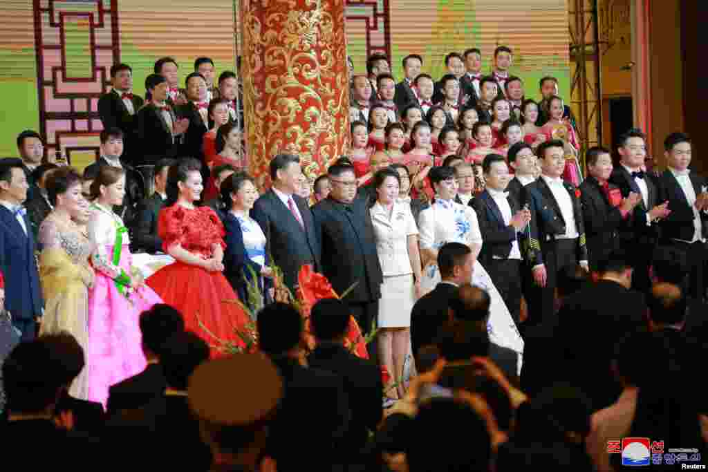2018年6月19日,中国国家主席习近平和夫人,朝鲜领导人金正恩和夫人参加欢迎宴会,观赏文艺演出后和歌唱家殷秀梅等演员们合影。6月20日,金正恩访华两天后返回平壤。中国是贫困的朝鲜的主要经济和外交盟友。