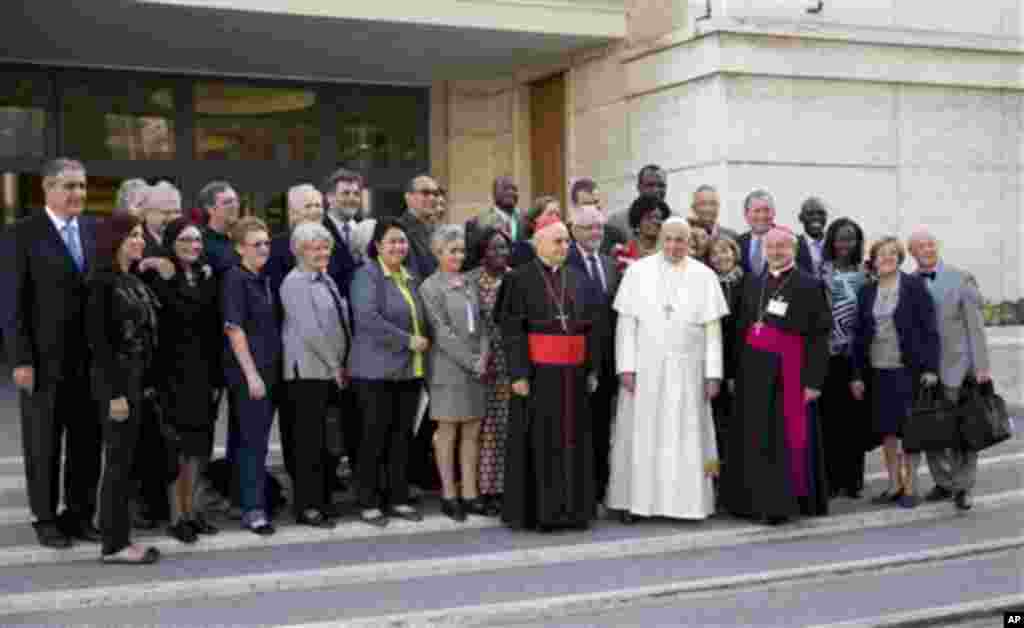 Pape François pose pour une photo avec les membres du laïcat à son arrivée pour une session d’après-midi au synode de deux semaines sur les questions de la famille, au Vatican, le vendredi 10 octobre 2014. Les défenseurs des droits des gays applaudissent prudemment applaudir un probable changement de ton de la Église catholique.(AP Photo/Andrew Medichini)