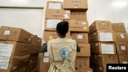 ARCHIVO - Un trabajador del Programa Mundial de Alimentos arregla paquetes de ayuda humanitaria a África para combatir el brote del coronavirus. Aeropuerto Internacional Addis Ababa, Etiopía.