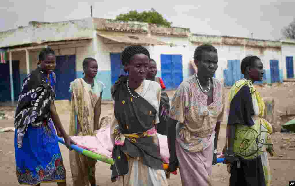 Para perempuan membawa mayat seorang warga sipil yang tewas di pusat kota Malakal, negara bagian Upper Nile di Sudan Selatan, 21 Januari 2014.