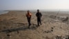 Bangladesh coast guards walk in the Thengar Char island in the Bay of Bengal, Bangladesh, Feb. 2, 2017.