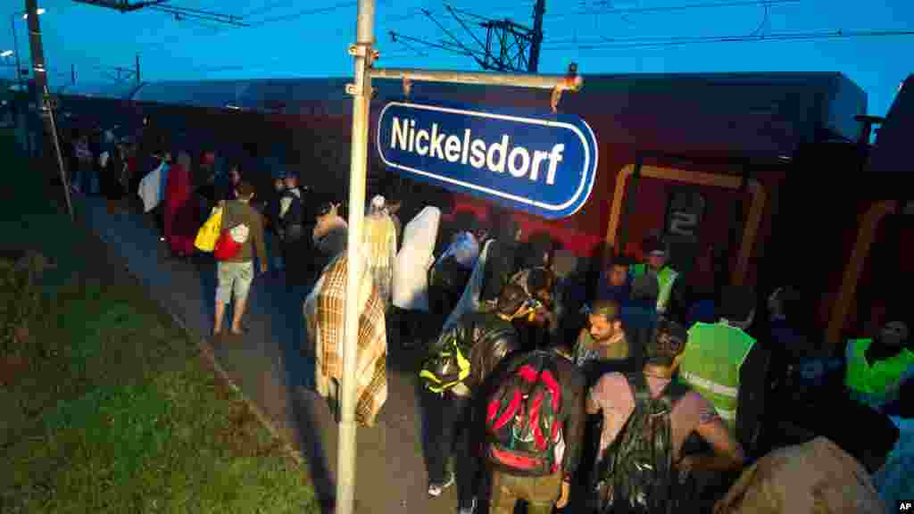 Des migrants montent dans le train après leur arrivée au poste frontalier entre Hegyeshalom, à Hongrie, et Nickelsdorf, em Autriche, samedi 5 septembre 2015
