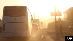 Bus-bus membawa pejuang al-Islam dan keluarganya, dari kota Douma, bekas pertahanan pemberontak, tiba di kota Azas, Suriah tanggal 5 April 2018 dalam perjalanan menuju kamp pengungsi (foto: AFP Photo/Nazeer al-Khatib)