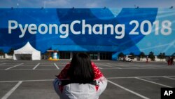 Seorang relawan mengambil gambar spanduk besar di Olympic Park menjelang Olimpiade Musim Dingin 2018, di Gangneung, Korea Selatan, 7 Februari 2018.