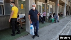 ARHIVA - Ljudi koji sumnjaju da su zaraženi koronavirusom čekaju ispred ulaza u Kliniku za tropske i infektivne bolesti Kliničkog centa Srbije, 26. juna 2020. (Rojters, Marko Đurica).