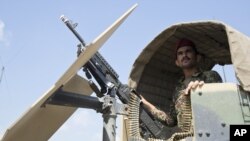 FILE - An Afghan National Army soldier stands guard in his vehicle in Camp Khogyani in Nangarhar province, east of Kabul — a region where homegrown militants loyal to the Islamic State group have made some inroads, Aug. 5, 2015.