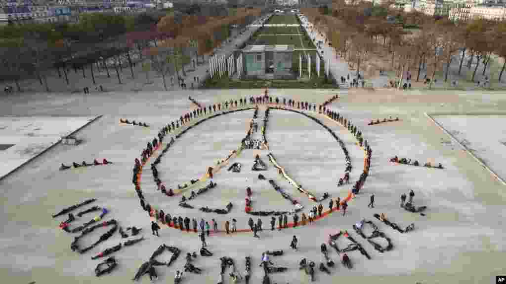 Des militants écologistes forment une chaîne humaine représentant le signe de la paix et mentionnant "100% renouvelable", en marge de la COP21, non loin de la Tour Eiffel, à Paris, 6 décembre 2015. 