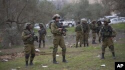 Israeli soldiers secure the scene after Palestinian teenager, Qusay Abo al-Rub, was shot and killed when he tried to stab a soldier in the village of Beita, south of the West Bank city of Nablus, Feb. 21, 2016.