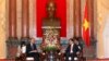 World Bank President Jim Young Kim (front L) and Vietnam's President Truong Tan Sang (front R) meet in front of a statue of late Vietnamese revolutionary leader Ho Chi Minh at the Presidential Palace in Hanoi, July 17, 2014.