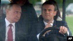 Le président russe Vladimir Poutine et le président français Emmanuel Macron dans le jardin du château de Versailles après leur rencontre à Versailles, près de Paris, France, le 29 mai 2017. 