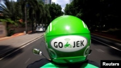 Pengemudi Go-Jek mengendarai sepeda motor di Jakarta, 15 Desember 2017.