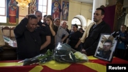Rodjaci ubijenog policajca Saše Samoilovskog ožalošćeni pored njegovog kovčega prekrivenog makedonskom zastavom, 10. maj, 2015.