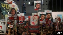 Demonstranti u Tel Avivu drže transparente sa fotografijama izraelskih talaca (Foto: AHMAD GHARABLI / AFP)