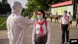 A una estudiante le toman la temperatura como parte de los procedimientos anti Covid-19 antes de ingresar a la Escuela Secundaria No. 1 de Pyongyang en Pyongyang, Corea del Norte, el 22 de junio de 2021.