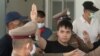 Pro-democracy activists flash three-fingered salutes during a demonstration at Victory Monument in Bangkok, Thailand, Oct. 21, 2020. Student activists applied to a Bangkok court to revoke a state of emergency the government declared last week.