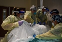 FILE - Healthcare personnel rotate a patient who is on a ventilator at a hospital in Hutchinson, Kansas, Nov. 20, 2020.