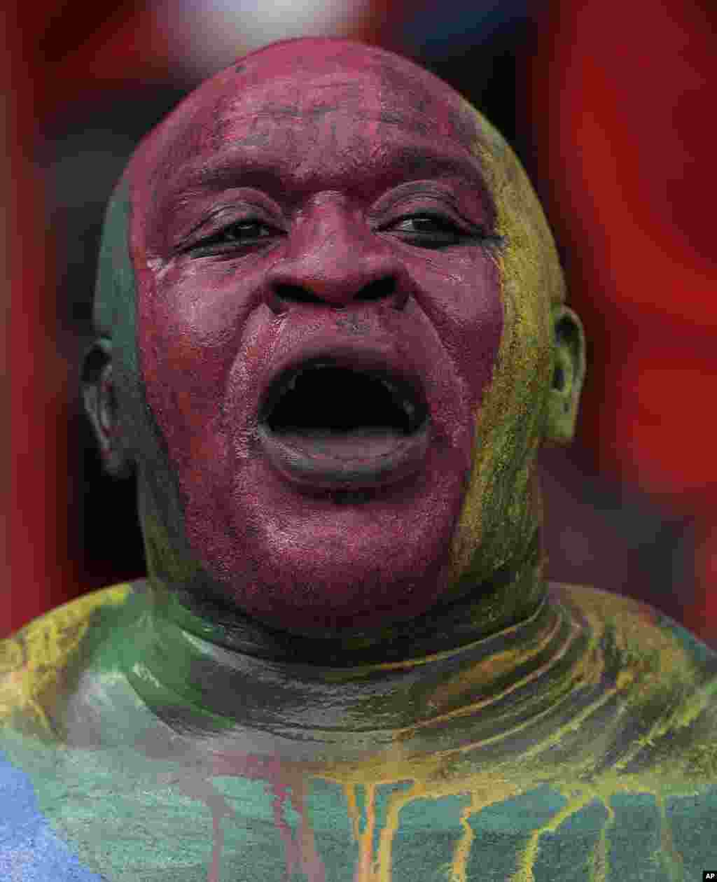 Un supporter Guinée équatoriale, visage peint aux couleurs nationales, scande lors de la rencontre de football de la Coupe d'Afrique des Nations Groupe A entre la Guinée équatoriale et le Burkina Faso à Bata, en Guinée équatoriale, mercredi 21 janvier 2015.
