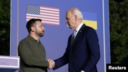 Президент США Джо Байден і президент України Володимир Зеленський тиснуть руки в день підписання безпекової угоди між США та Україною в Італії, 13 червня 2024 року. REUTERS/Kevin Lamarque