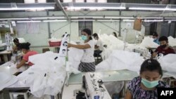 科学家建议在室内要戴口罩以避免病毒传播。图为戴口罩的缅甸工人在仰光的一家工厂内缝制手术用口罩。2020年5月8日图片。