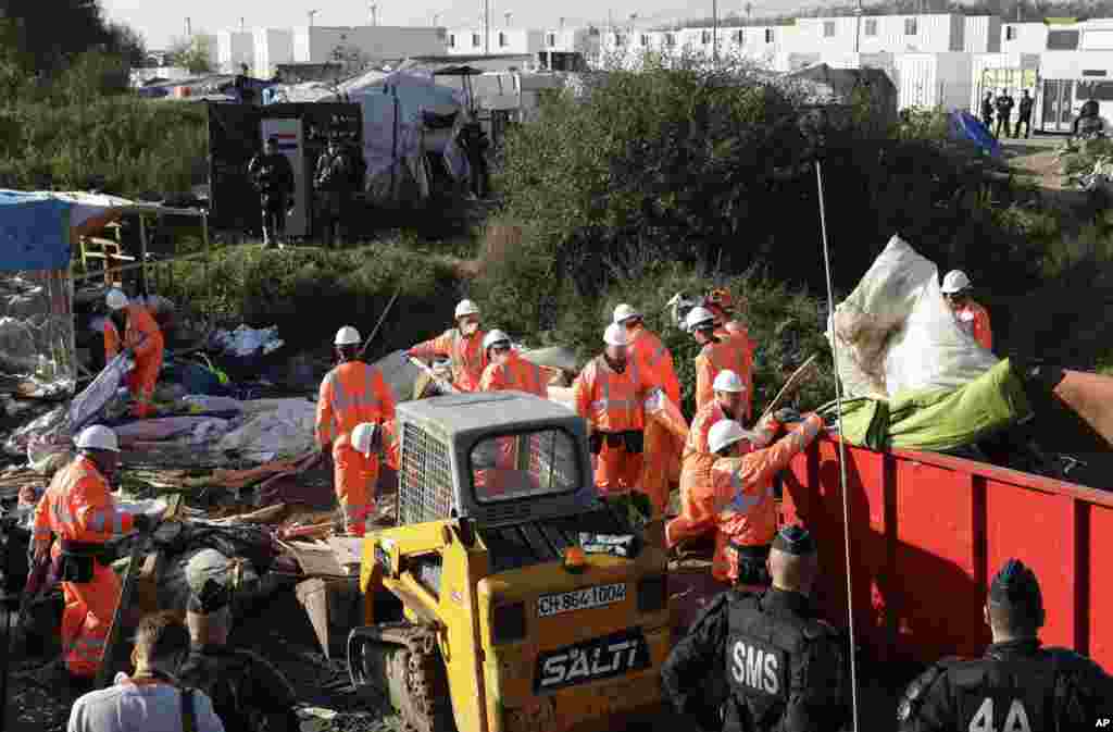 Petugas menghancurkan kamp migran "The Jungle" di Calais, Perancis utara (25/10). (AP/Matt Dunham)