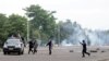 Congolese policemen run to their vehicle during a clash with opposition activists participating in a march to press President Joseph Kabila to step down in the Democratic Republic of Congo's capital Kinshasa, Sept. 19, 2016. 