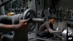 Nizam, 11, works at a factory that makes metal utensils in Dhaka, Bangladesh, June 12, 2016. 