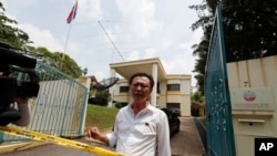 Seorang pegawai kedutaan Korea Utara bertanya kepada polisi apakah mereka diperbolehkan meninggalkan tempat tersebut, pada saat polisi menempatkan garis penjagaan di Kedutaan Korut di Kuala Lumpur, Malaysia, 7 Maret 2017. (AP Photo/Vincent Thian)