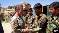FILE - Resolute Support Mission Commander, U.S. Army General Austin Scott Miller, right, shakes hands with Afghanistan's Foreign Minister Salahuddin Rabbani during a meeting in Brussels, Dec. 5, 2018.