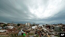 Storm clouds build in the distance beyond tornado-ravaged homes in Moore, Oklahoma, May 21, 2013. 