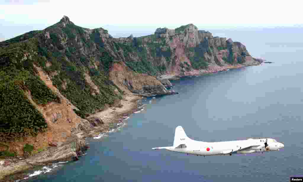 Pesawat pengintai Pasukan Pertahanan Maritim Jepang terbang di atas pulau Uotsuri Jima/Diaoyu Dao, 13 Oktober 2011.