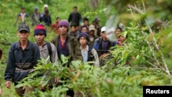 Montagnard hill tribesmen walk towards the main road after emerging from dense forest 70 km (43 miles) northeast of Ban Lung, located in Cambodia's northeastern province of Ratanakiri, file photo. 