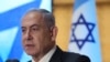 Un activista pega un cartel en la base de una farola en protesta contra la visita del primer ministro israelí, Benjamín Netanyahu, el 21 de julio en Washington.