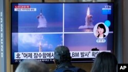 La gente mira una pantalla de televisión que muestra imágenes del lanzamiento de un misil balístico de Corea del Norte desde un submarino, durante un programa de noticias en la estación de tren de Seúl en Seúl, Corea del Sur, el 20 de octubre de 2021.