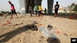 Civilians gather at the site of a suicide bomb attack in Baghdad's western Iskan neighborhood, Iraq, Oct. 29, 2016. Iraqi officials say a suicide bomber targeting Shiiite pilgrims has killed seven people and wounded more than 20 in the Iraqi capital, Bagh