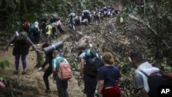 Migrantes cruzan el Tapón del Darién desde Colombia a Panamá en su largo y difícil viaje para llegar a Estados Unidos, el 9 de mayo de 2023. El sábado 6 de abril el gobierno colombiano anunció una medida que beneficia a migrantes venezolanos en Colombia.