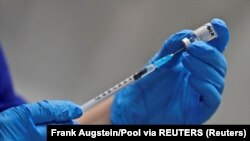 Seorang perawat menyiapkan suntikan vaksin COVID-19 buatan Pfizer-BioNTech di Rumah Sakit Guy's di London, Inggris, 8 Desember 2020.