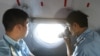 A military personnel takes photos from the window of an aircraft belonging to the Vietnamese airforce during a search and rescue mission off Vietnam's Tho Chu island, March 10, 2014. 