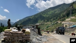 Tentara paramiliter India berjaga-jaga saat konvoi tentara India bergerak di sepanjang jalan raya Srinagar-Ladakh di Gagangeer, India, 18 Juni 2020. ketika perselisihan antara India dan Cina di Lembah Himalaya Galwan meningkat.