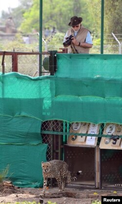 India's Prime Minister Narendra Modi holds a camera after he released cheetahs following their translocation from Namibia, in Kuno National Park, Madhya Pradesh, India, September 17, 2022. (India's Press Information Bureau/Handout via REUTERS)