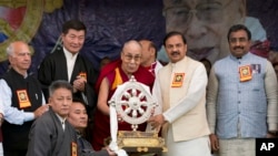 Tibetan spiritual leader the Dalai Lama presents a memento to Junior Indian Culture Minister Mahesh Sharma, second right, as he arrives to attend an event marking the beginning of the 60th year of the Dalai Lama's exile in India, in Dharmsala, India, Marc